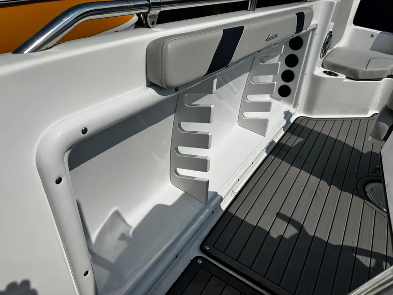 Slide: The Image of 2024 Godfrey 231 Center Console boat interior with rod holders and cushioned seating. - 16