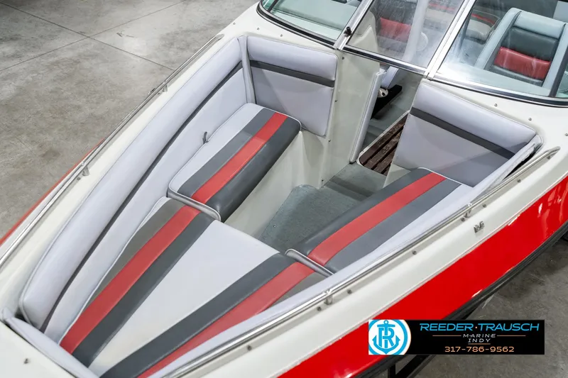 Slide: The Image of Interior of a 1991 Caravelle I2300CC boat with red and gray seating. - 10