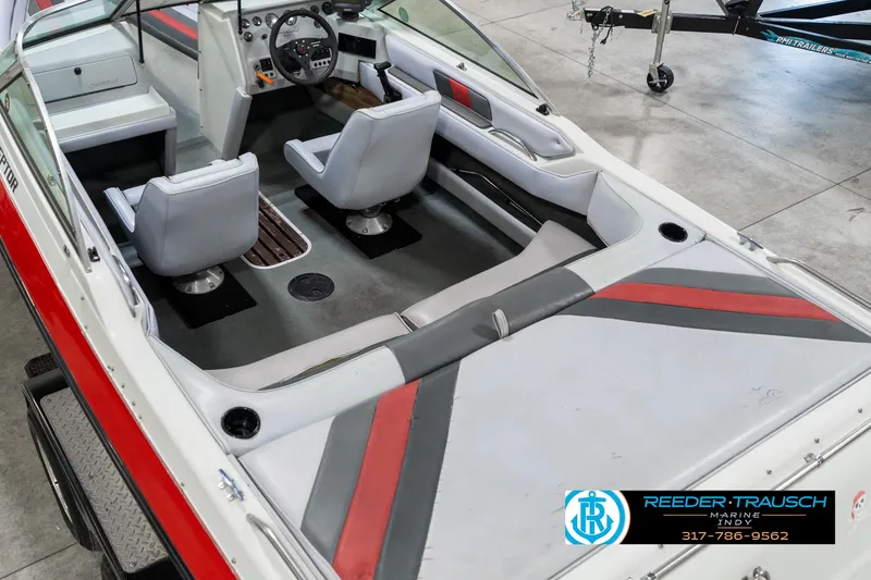 Slide: The Image of 1991 Caravelle I2300CC boat interior with gray and red seating, steering wheel, and dashboard. - 13