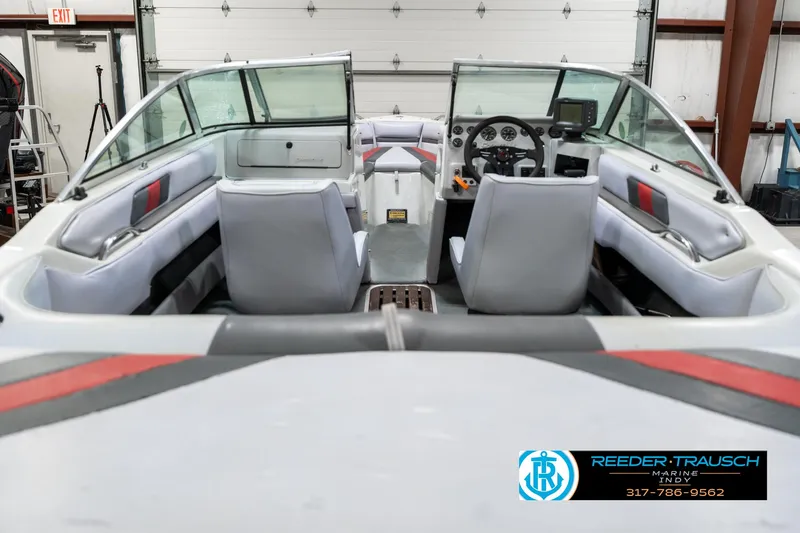 Slide: The Image of Interior of a 1991 Caravelle I2300CC boat with gray and red seating. - 14