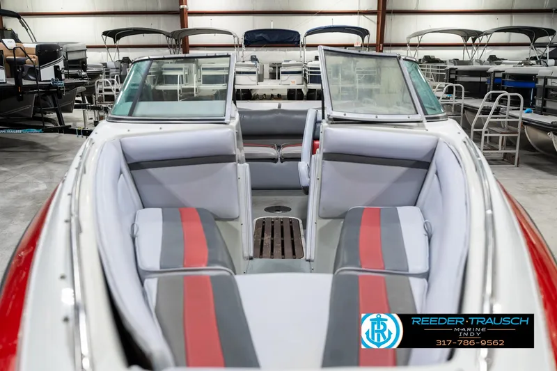 Slide: The Image of 1991 Caravelle I2300CC boat interior with red and gray seating in a showroom. - 17