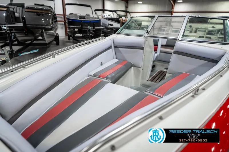 Slide: The Image of 1991 Caravelle I2300CC boat interior with red and gray seating in showroom. - 20