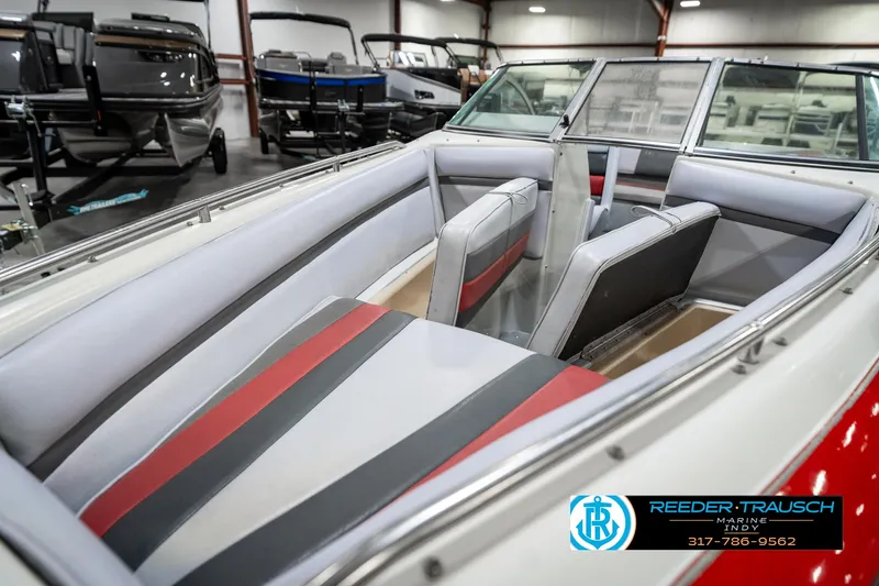 Slide: The Image of Interior of a 1991 Caravelle I2300CC boat with red and gray seating. - 21