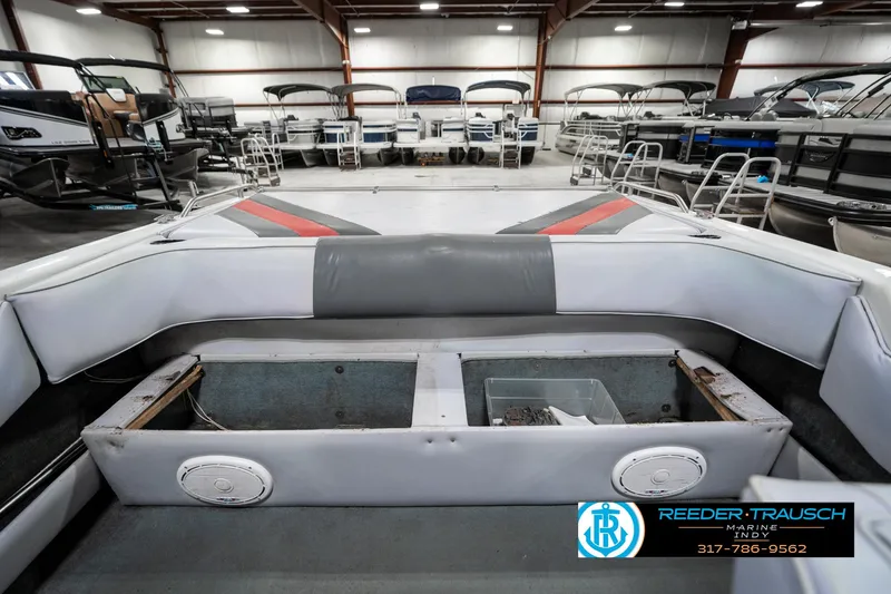 Slide: The Image of Interior of a 1991 Caravelle I2300CC boat in a showroom, featuring seating and storage. - 23