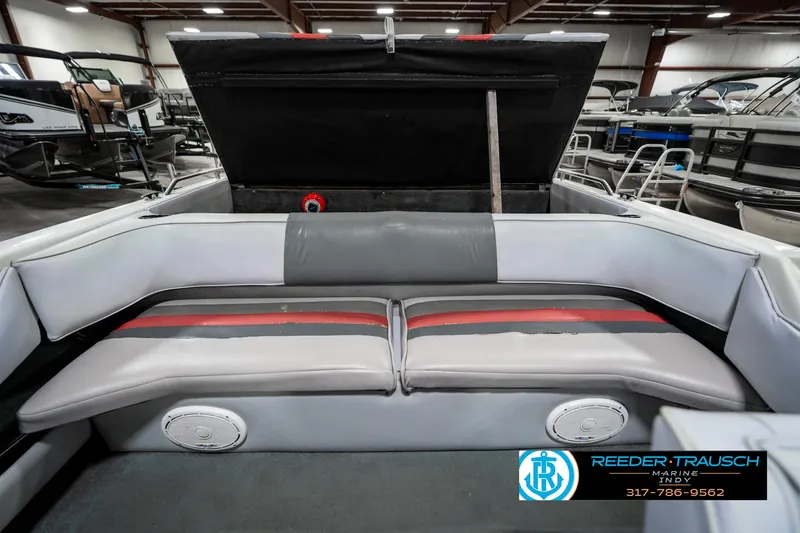 Slide: The Image of 1991 Caravelle I2300CC boat interior with gray and red seating in a showroom. - 24