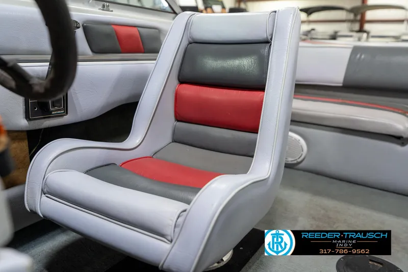 Slide: The Image of 1991 Caravelle I2300CC boat interior with red and gray seating, Reeder-Trausch Marine logo visible. - 33