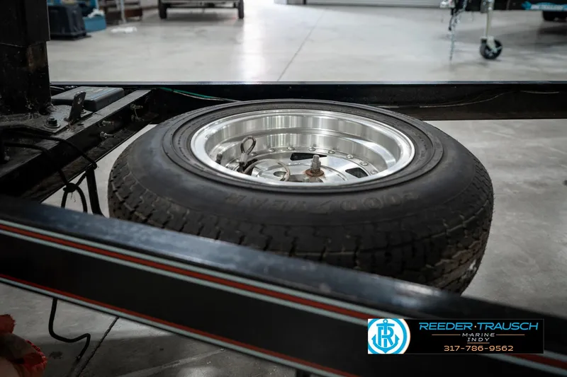 Slide: The Image of Spare tire mounted on a Caravelle I2300CC trailer, 1991 model, in a workshop setting. - 43