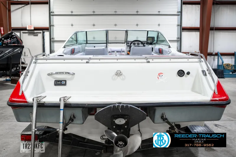 Slide: The Image of Rear view of a 1991 Caravelle I2300CC boat in a garage setting. - 7