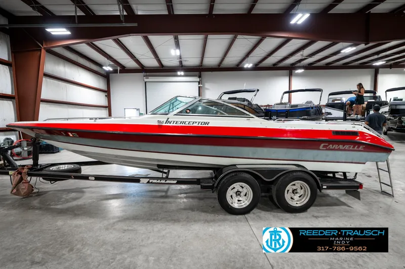 Slide: The Image of 1991 Caravelle I2300CC boat on trailer in indoor showroom. - 9