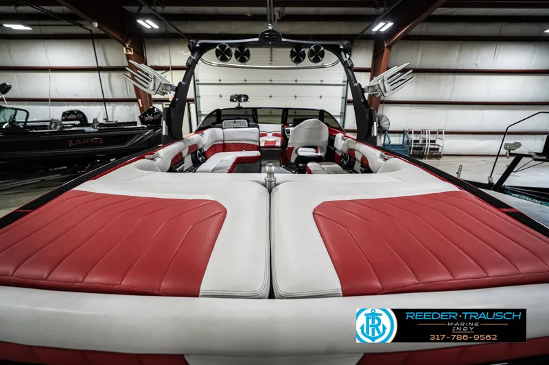 Slide: The Image of 2017 Malibu Wakesetter 25 LSV interior with red and white seating in a showroom. - 15