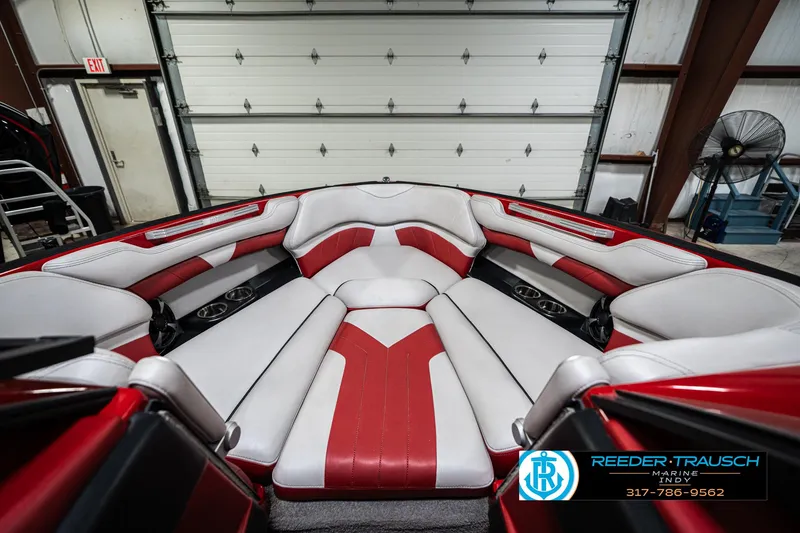 Slide: The Image of 2017 Malibu Wakesetter 25 LSV interior with red and white seating in a garage. - 17