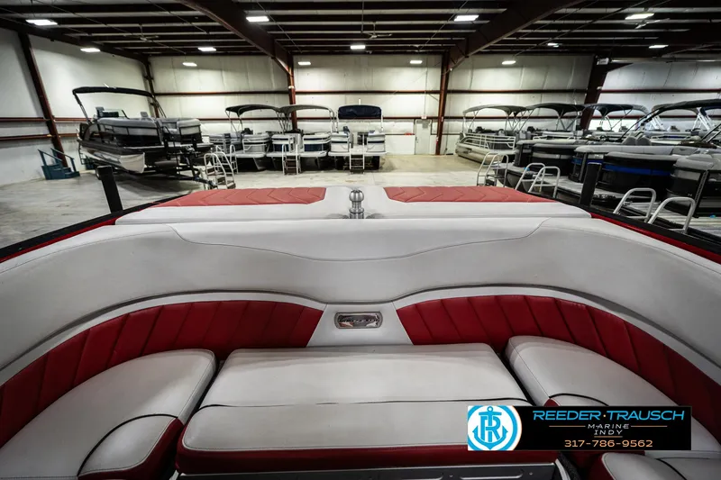 Slide: The Image of 2017 Malibu Wakesetter 25 LSV interior with red and white seating in a showroom. - 20