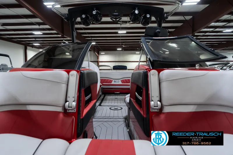 Slide: The Image of 2017 Malibu Wakesetter 25 LSV interior with red and white seating in a showroom. - 21