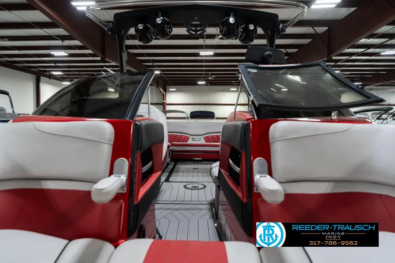 Slide: The Image of 2017 Malibu Wakesetter 25 LSV interior with red and white seating in a showroom. - 22