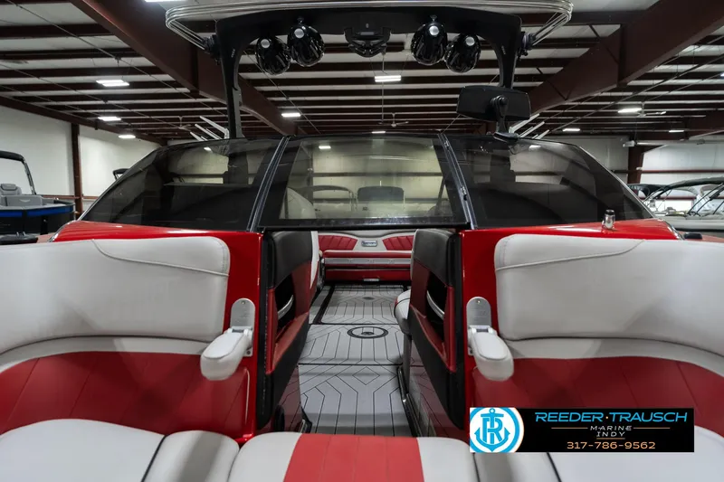 Slide: The Image of 2017 Malibu Wakesetter 25 LSV interior with red and white seating in a showroom. - 23