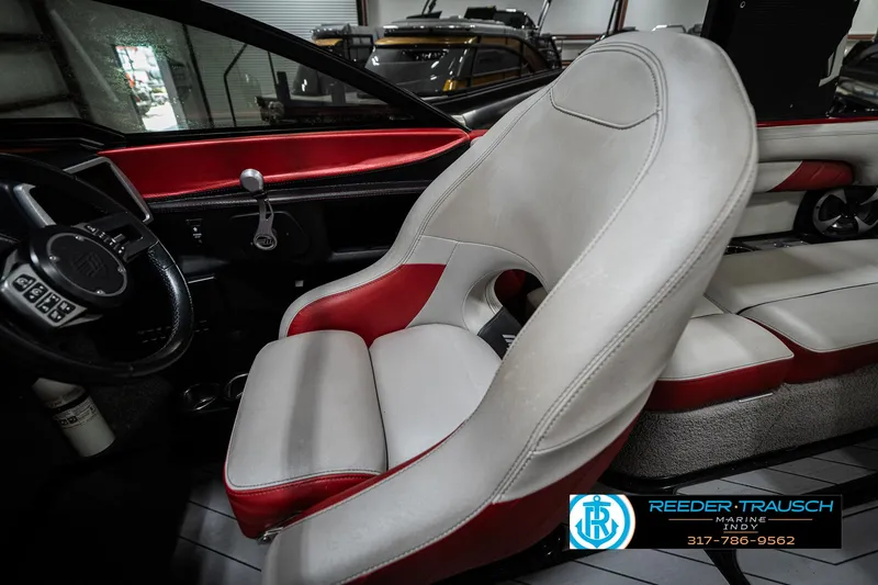Slide: The Image of 2017 Malibu Wakesetter 25 LSV interior with red and white seating, steering wheel, and controls. - 24