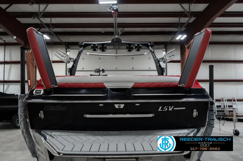 Slide: The Image of 2017 Malibu Wakesetter 25 LSV boat in a warehouse, rear view with open compartments. - 41