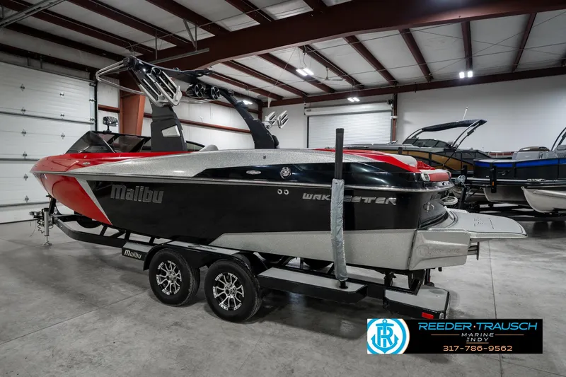 Slide: The Image of 2017 Malibu Wakesetter 25 LSV boat in showroom, red and black design, on trailer. - 5