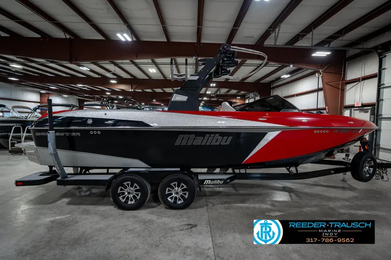Slide: The Image of 2017 Malibu Wakesetter 25 LSV boat in showroom, red and black design, on trailer. - 8