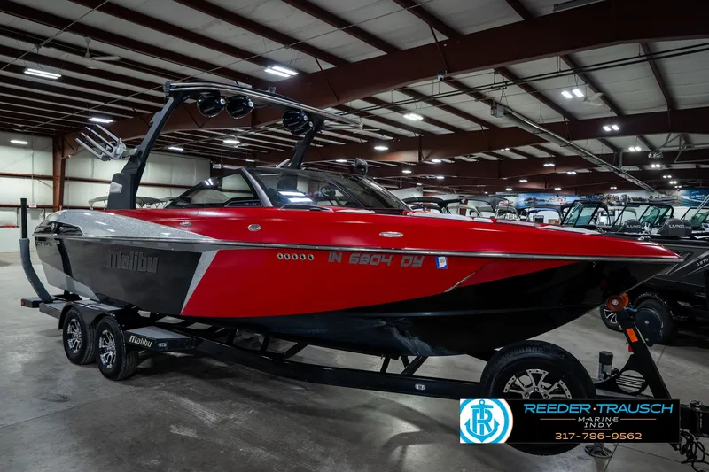 Slide: The Image of 2017 Malibu Wakesetter 25 LSV boat in showroom, red and black design, on trailer. - 9