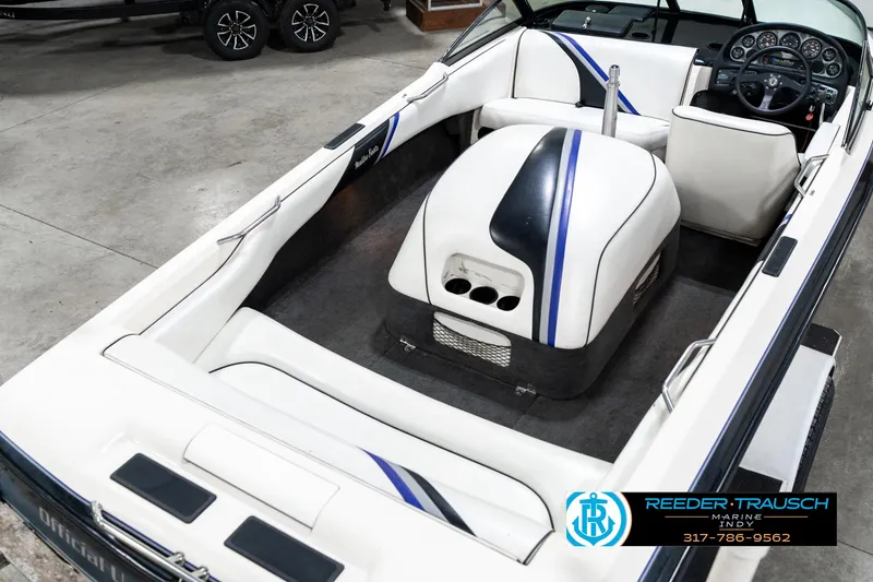 Slide: The Image of 1997 Malibu Response boat interior with white and blue seating, dashboard, and steering wheel. - 12
