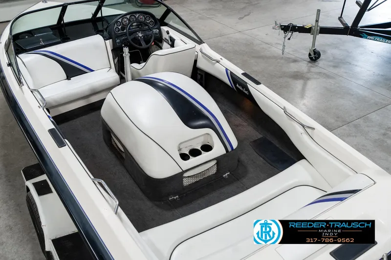 Slide: The Image of 1997 Malibu Response boat interior with white and blue seating, dashboard, and steering wheel. - 13