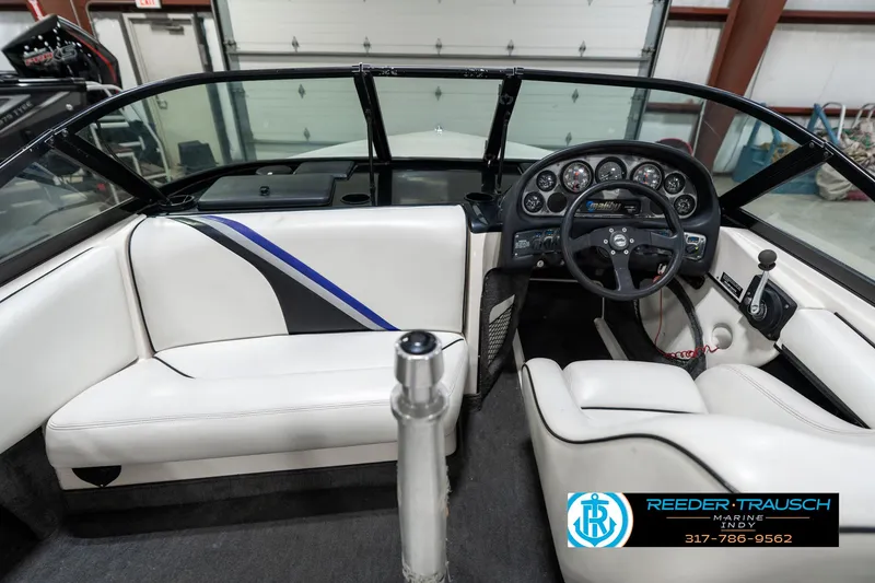 Slide: The Image of 1997 Malibu Response boat interior with white seating and detailed dashboard. - 15