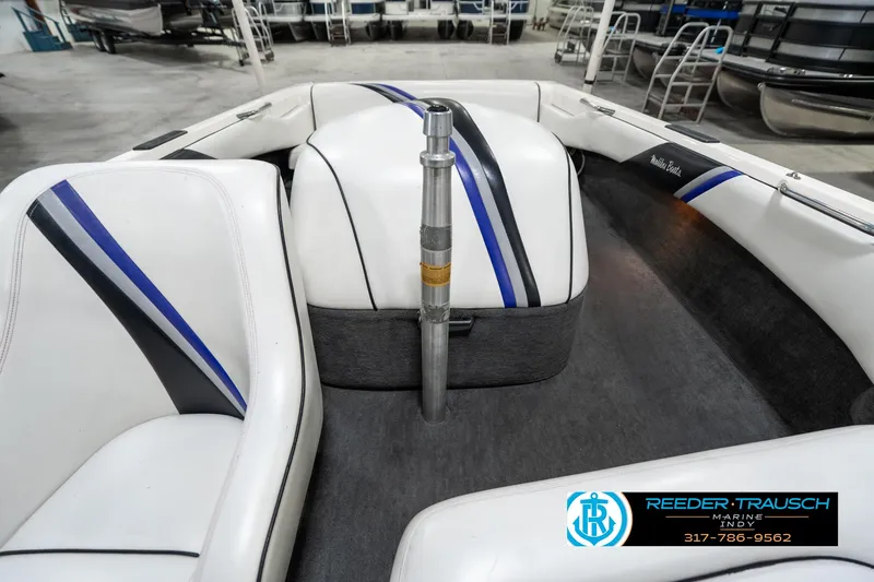 Slide: The Image of 1997 Malibu Response boat interior with white and blue seating in a showroom. - 16