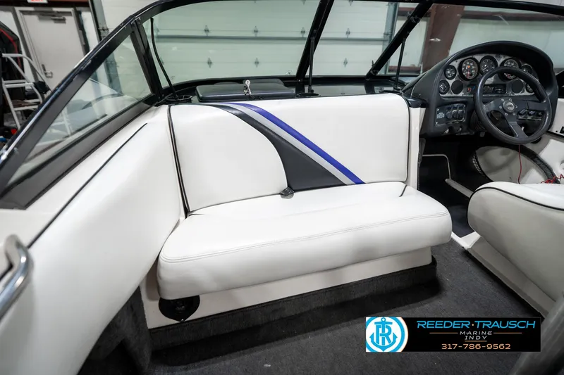 Slide: The Image of 1997 Malibu Response boat interior with white seating and dashboard, featuring Reeder-Trausch Marine logo. - 18
