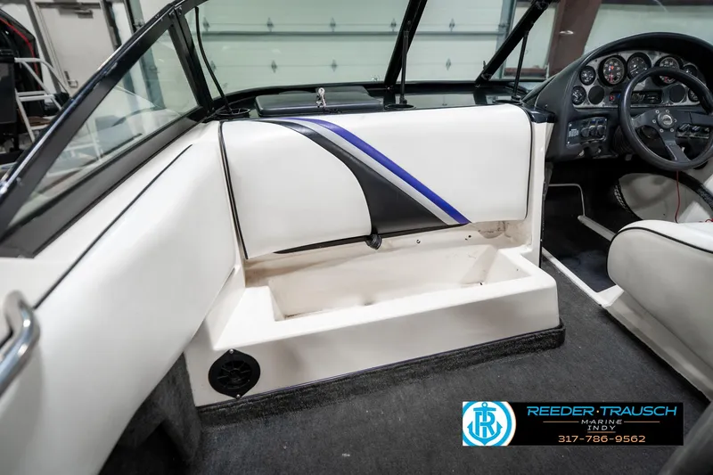 Slide: The Image of 1997 Malibu Response boat interior with white seating and dashboard, featuring blue accents. - 20