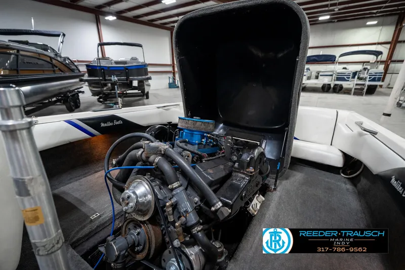 Slide: The Image of 1997 Malibu Response boat engine in a showroom with other boats. - 22
