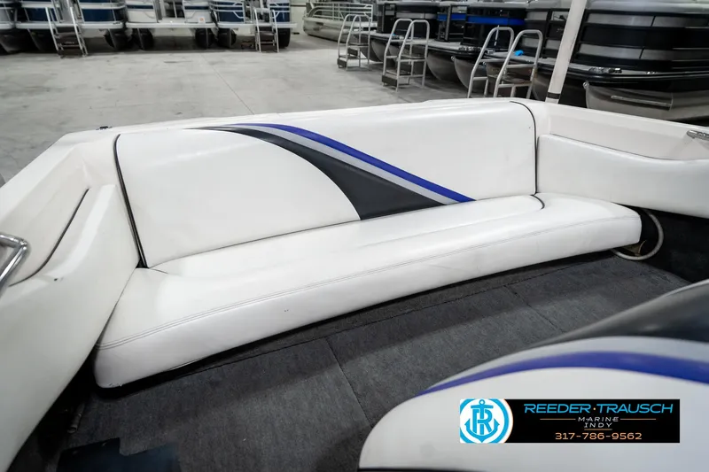 Slide: The Image of 1997 Malibu Response boat interior with white and blue seating in a showroom. - 23