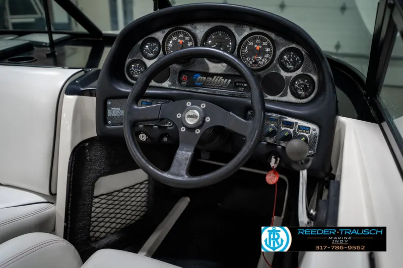 Slide: The Image of 1997 Malibu Response boat dashboard with steering wheel and instrument panel. - 26