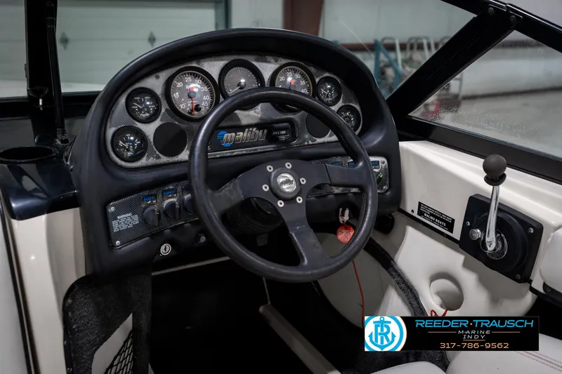 Slide: The Image of 1997 Malibu Response boat dashboard with steering wheel and control panel. - 27