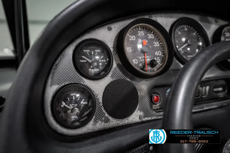 Slide: The Image of Dashboard of a 1997 Malibu Response boat with gauges and steering wheel. - 30