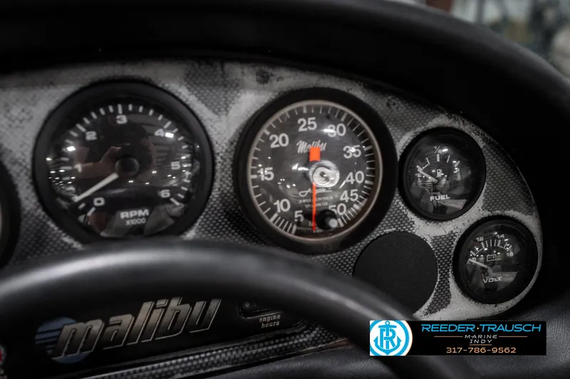 Slide: The Image of Dashboard of a 1997 Malibu Response boat with gauges and logo. - 31