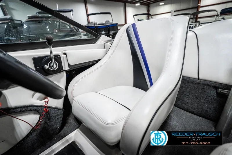 Slide: The Image of 1997 Malibu Response boat interior with white and blue seating, steering wheel, and control panel. - 34