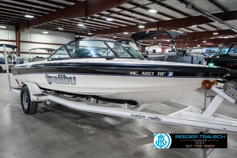 Slide: The Image of 1997 Malibu Response boat on trailer in indoor showroom. - 4