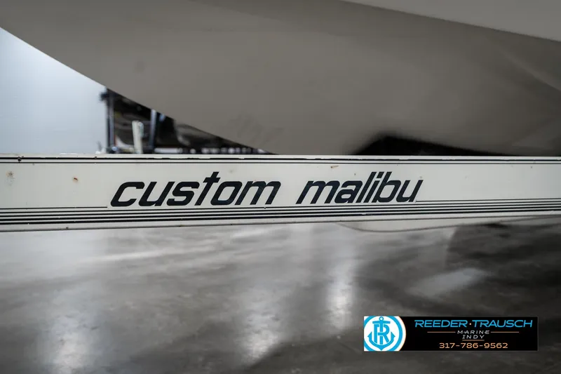 Slide: The Image of 1997 Malibu Response boat trailer with "custom malibu" branding in a showroom. - 42