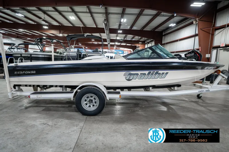 Slide: The Image of 1997 Malibu Response boat on trailer in indoor showroom. - 5