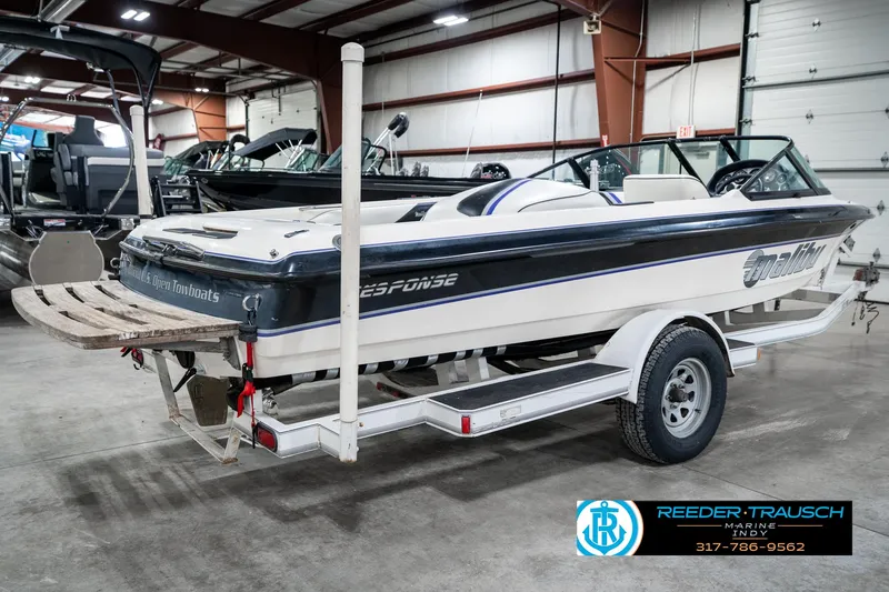 Slide: The Image of 1997 Malibu Response boat on trailer in indoor showroom. - 6