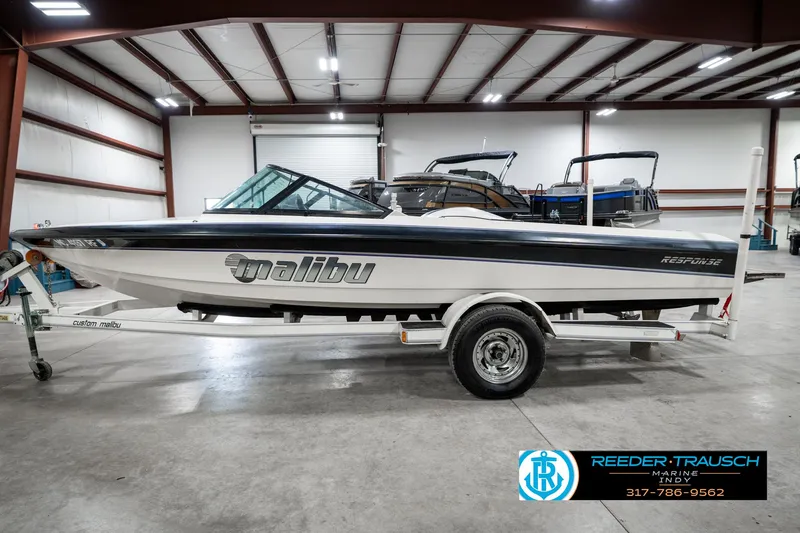 Slide: The Image of 1997 Malibu Response boat in a showroom, side view on a trailer. - 9