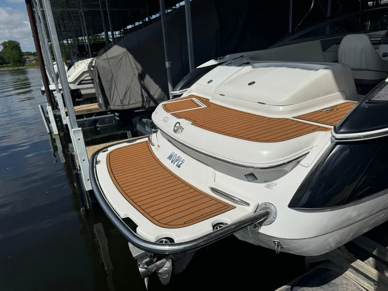 Slide: The Image of 2002 Cobalt 240 boat docked, featuring teak-style swim platform and sleek design. - 2