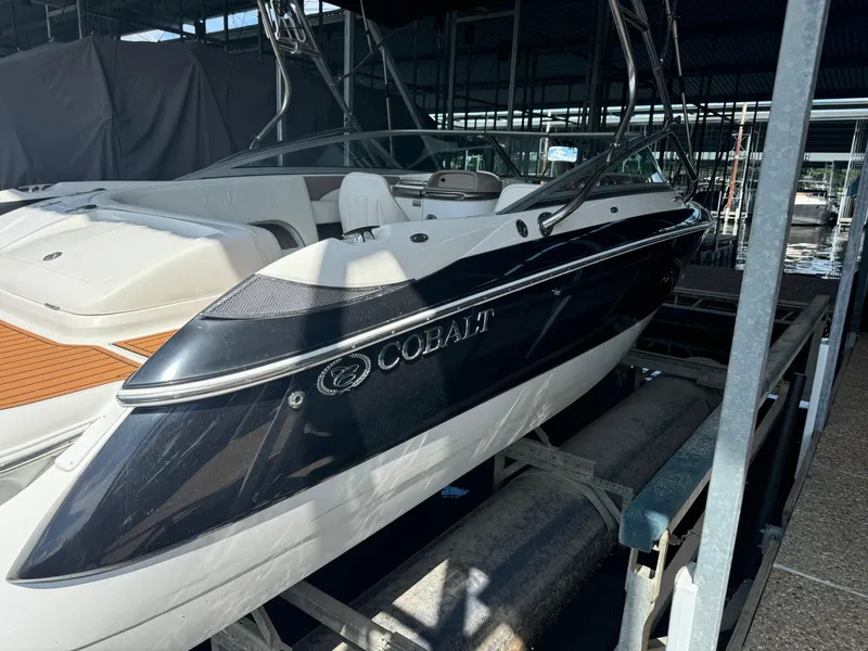 Slide: The Image of 2002 Cobalt 240 boat in dock, sleek design, black and white exterior. - 3