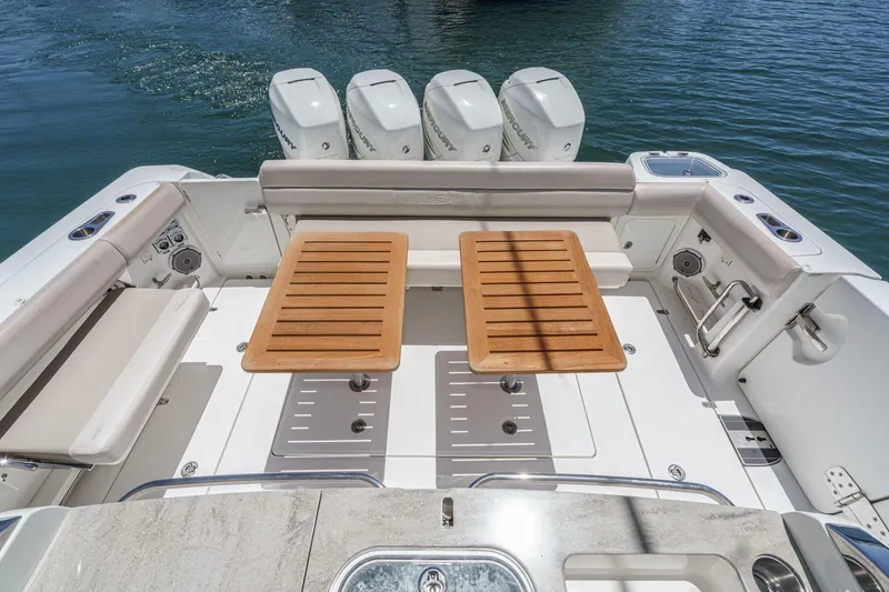 Slide: The Image of 2017 Boston Whaler 42 OUTRAGE boat deck with seating and wooden tables. - 28