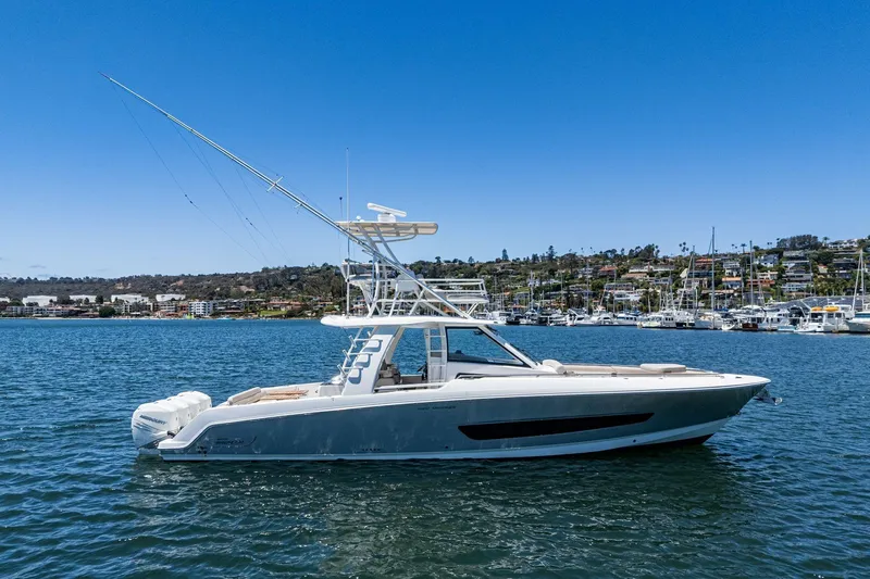 Slide: The Image of 2017 Boston Whaler 42 OUTRAGE boat on calm water, clear sky, marina background. - 4