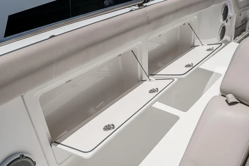 Slide: The Image of 2017 Boston Whaler 42 OUTRAGE boat storage compartments with open hatches and speakers. - 54