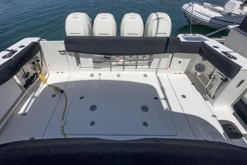 Slide: The Image of 2017 Boston Whaler 42 OUTRAGE boat deck with four engines, docked on calm water. - 76