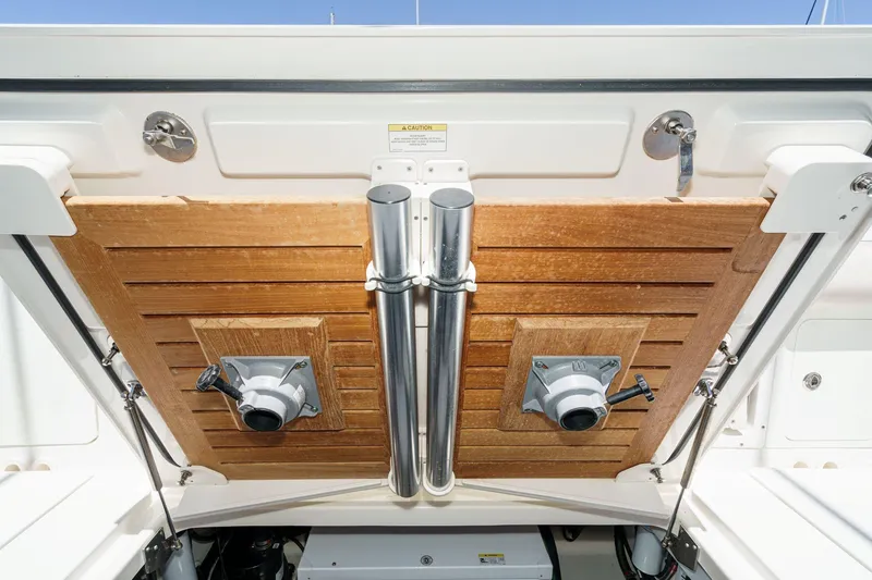 Slide: The Image of 2017 Boston Whaler 42 OUTRAGE boat storage compartment with wooden panels and metal fixtures. - 84