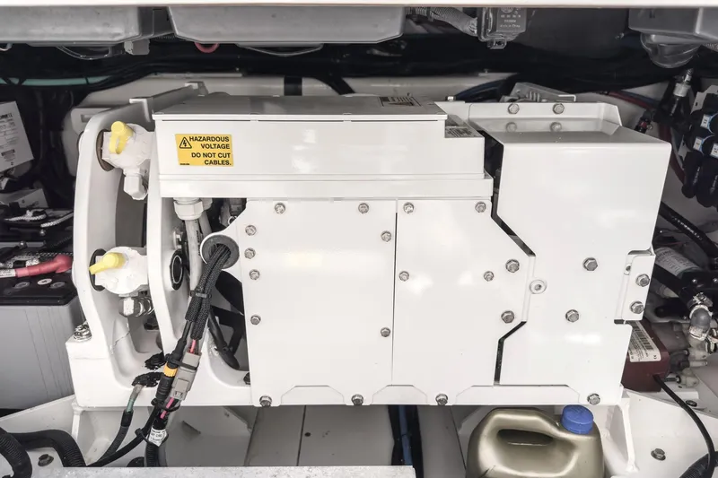 Slide: The Image of Engine compartment of 2017 Boston Whaler 42 OUTRAGE with hazardous voltage warning. - 87